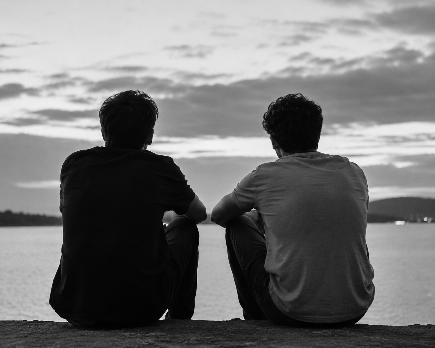 Two mates sitting side by side looking out over the water